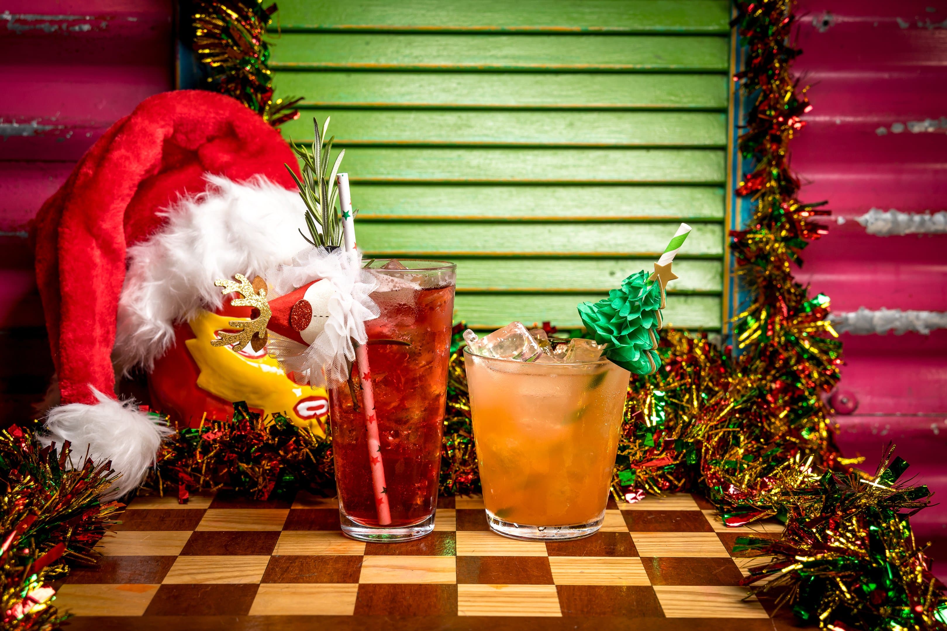 Two christmas cocktails with festive garnishes