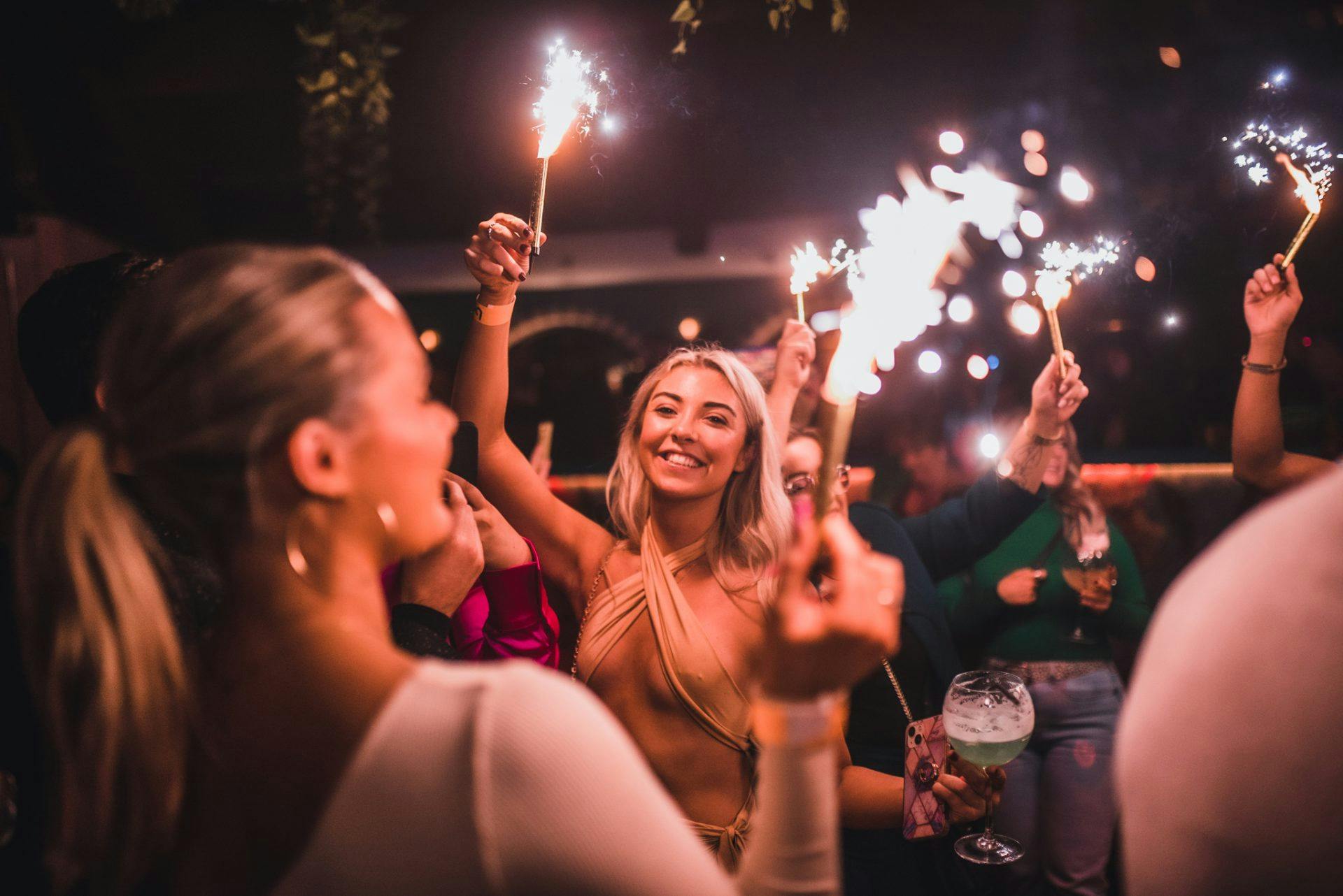 Customers holding bottle sparklers at Barrio Bars