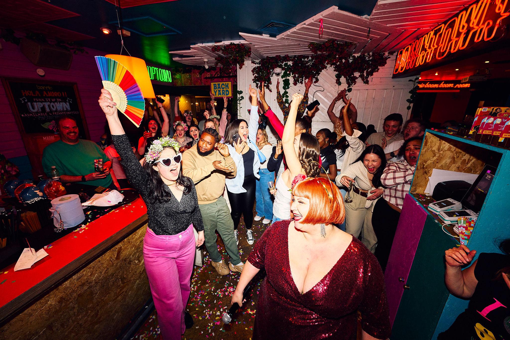 A busy bar filled with customers dancing